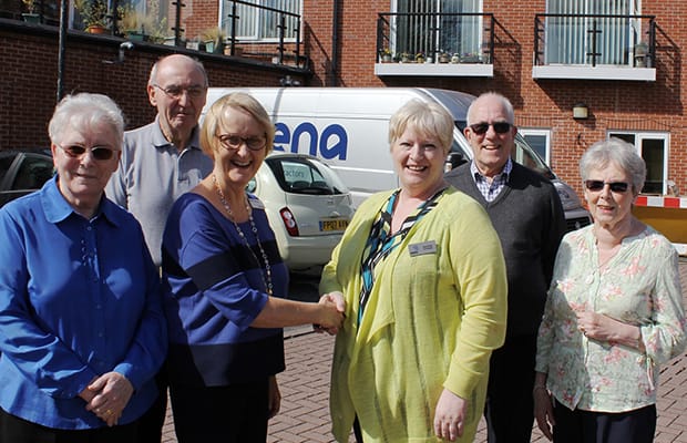 Bromford’s Helen Shields shakes hands with Radis Community Care area manager Joan Trevis outside Beacon Park Village, alongside residents Lilian and Brian Ashwell and David and Joan Lambert