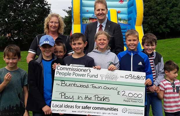 Heather Tranter and young visitors to a Play in the Parks event receive the funding cheque from Crime Commissioner Matthew Ellis