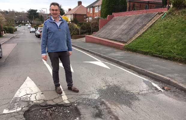 Cllr Paul Ray with one of the potholes on Dimbles Hill