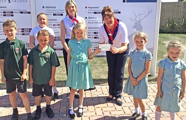 The cheque is presented to pupils from Henry Chadwick Primary School