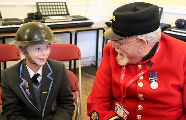 A Chelsea Pensioner talking to a student at Maple Hayes