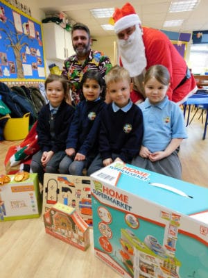 Teaching assistant Mr Heath with Father Christmas and children at St Stephen's Primary School in Fradley
