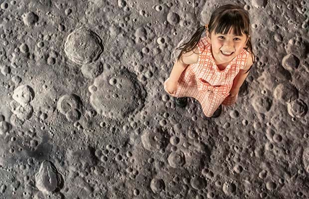 A girl on a projection of the moon surface in Lichfield Cathedral