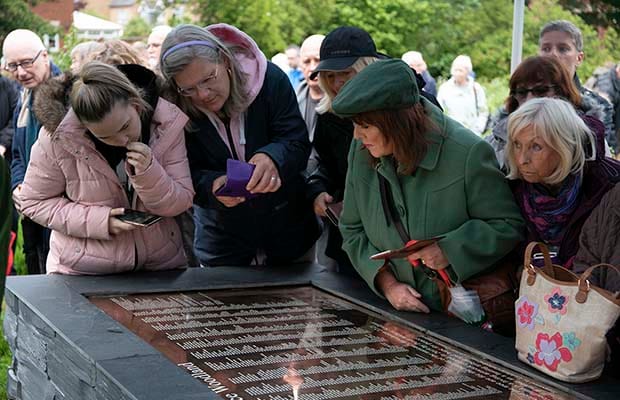 Visitors examining the new Peace Woodland plaque. Pic: Hannah Golding