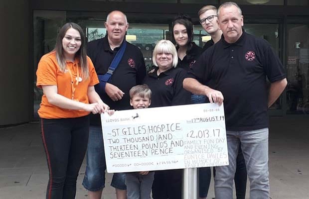 Beth Richardson from St Giles Hospice receiving the fundraising cheque from Mike Davies, Eunice Davies, Lauren Hardwick, Josh Allen, Tony Hardwick and Edward Hardwick