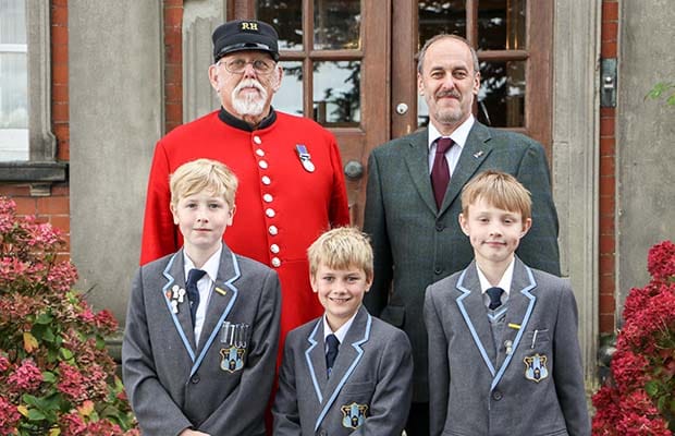 Chelsea Pensioner Peter Turner with Dr Daryl Brown and pupils William Haynes, Charlie Petty and Billy Bostock