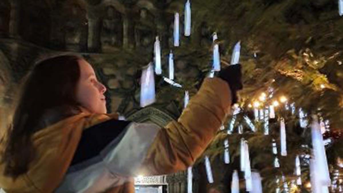 A visitor adding a glow stick to the tree at the Light Up A Life service