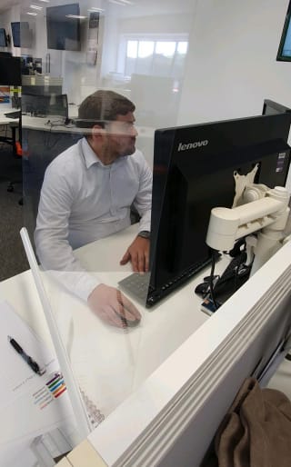 A member of staff using the Rollerscreen at their desk