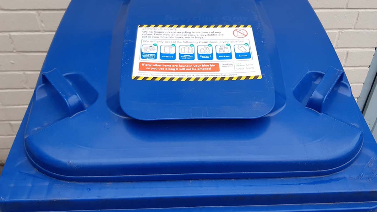A new recycling guidance sticker on a blue bin