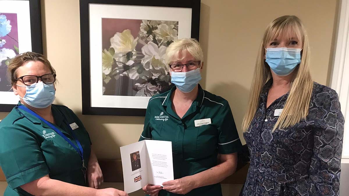 Staff at The Spires care home with the card from the Lord-Lieutenant of Staffordshire