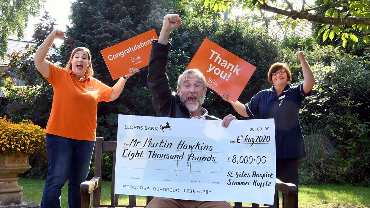 Martin Hawkins celebrates his lottery win with lottery manager Alison Jerram and ward manager Sharon Meehan