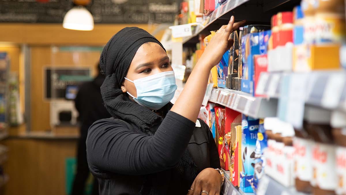 A Central England Co-op worker wearing a face mask