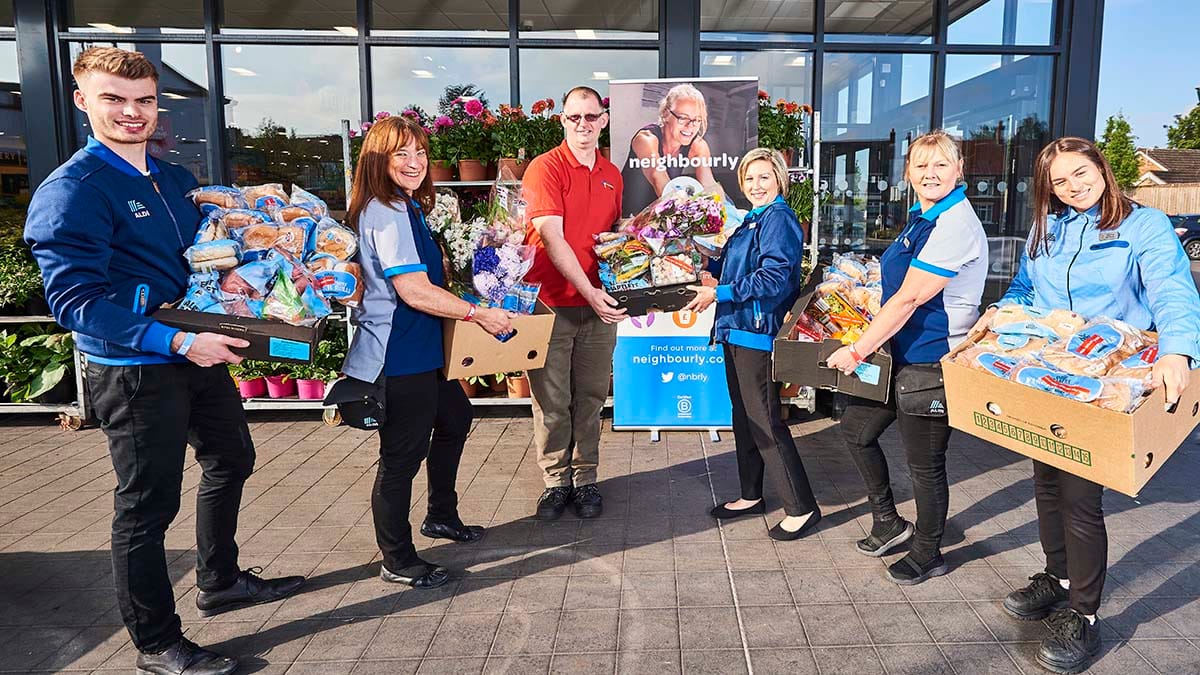 Staff with food donations outside an Aldi store