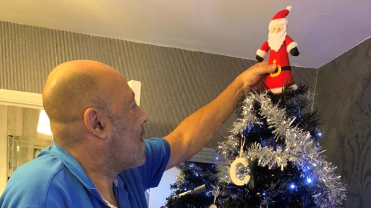 Charlie putting Santa on the top of the Christmas tree