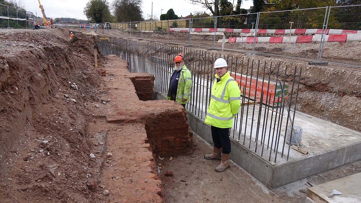 Peter Buck and Dan Hassall stand between the newly excavated Heritage Lock 23 and the concrete base for a retaining wall