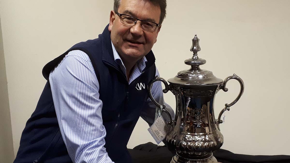 Auctioneer Richard Winterton with the replica FA Cup trophy