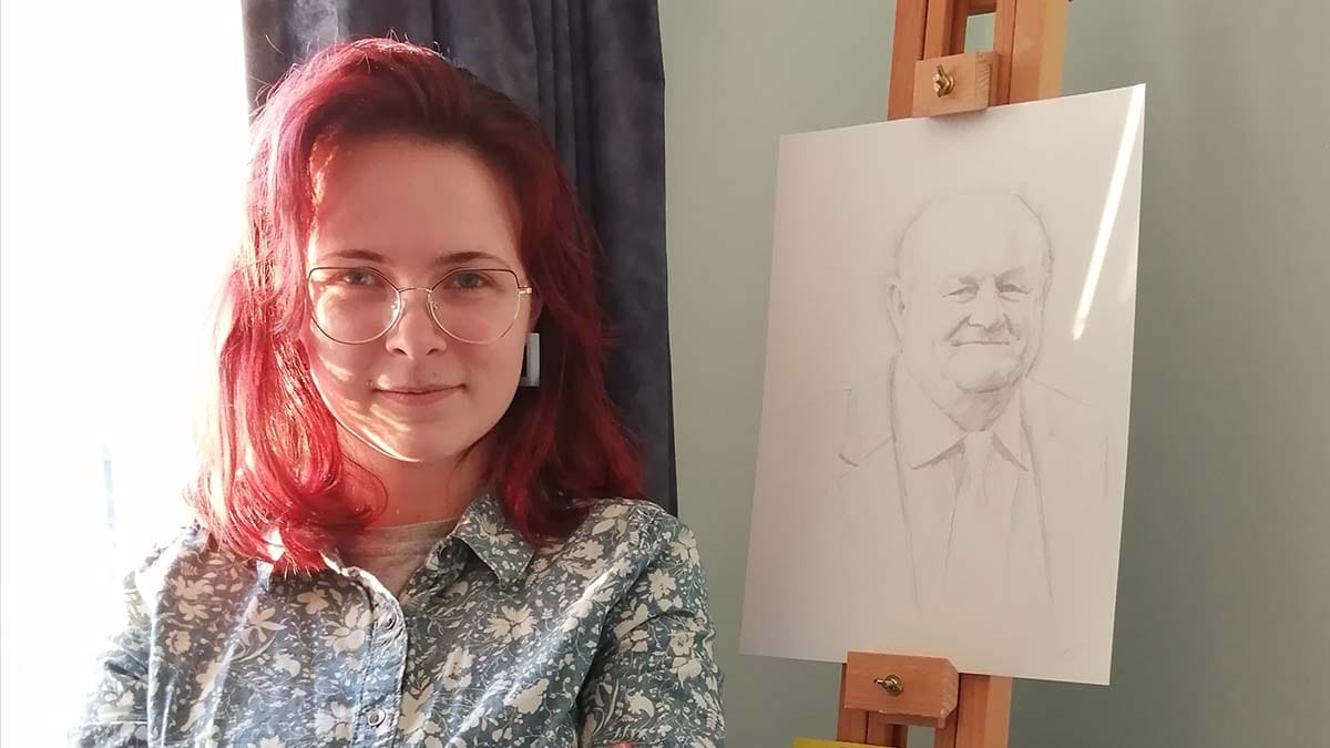 Sarah Devlin alongside her portrait of John Woodward OBE