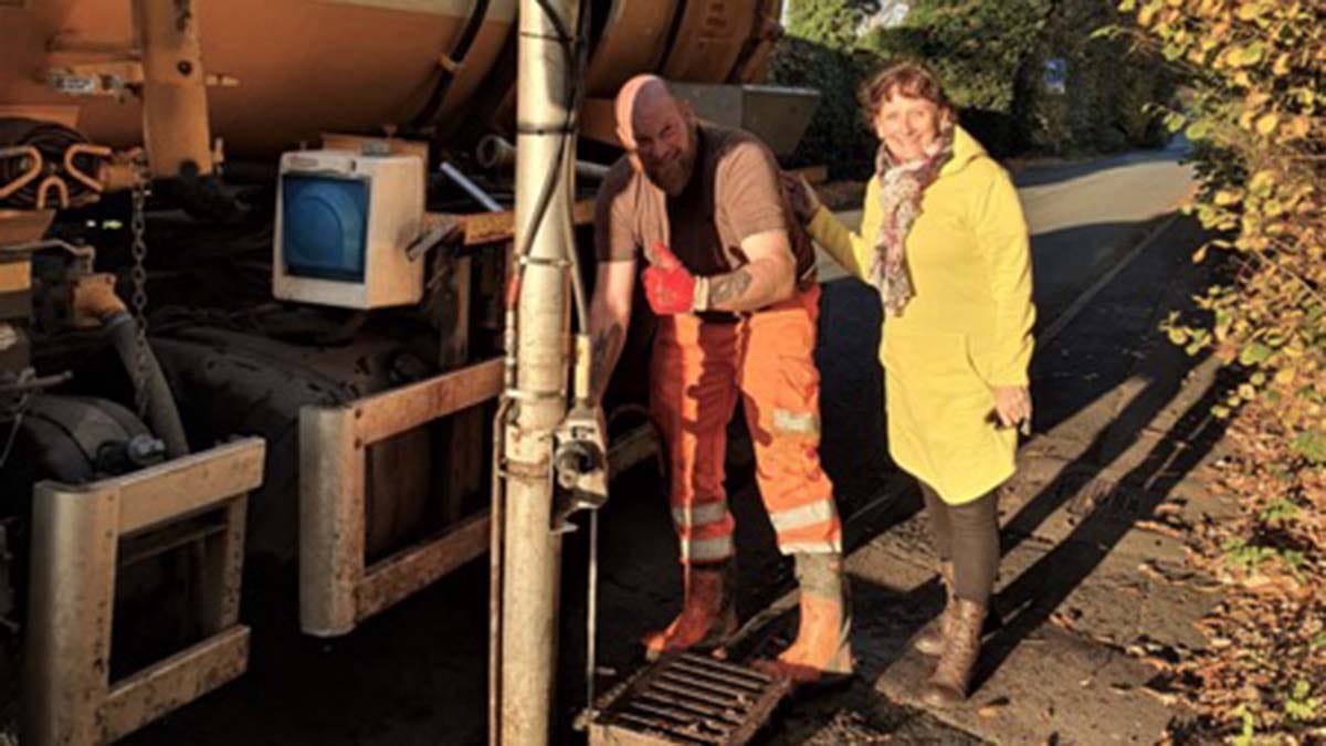Cllr Janet Taylor joins an employee from Burntwood Environmental to clear drains