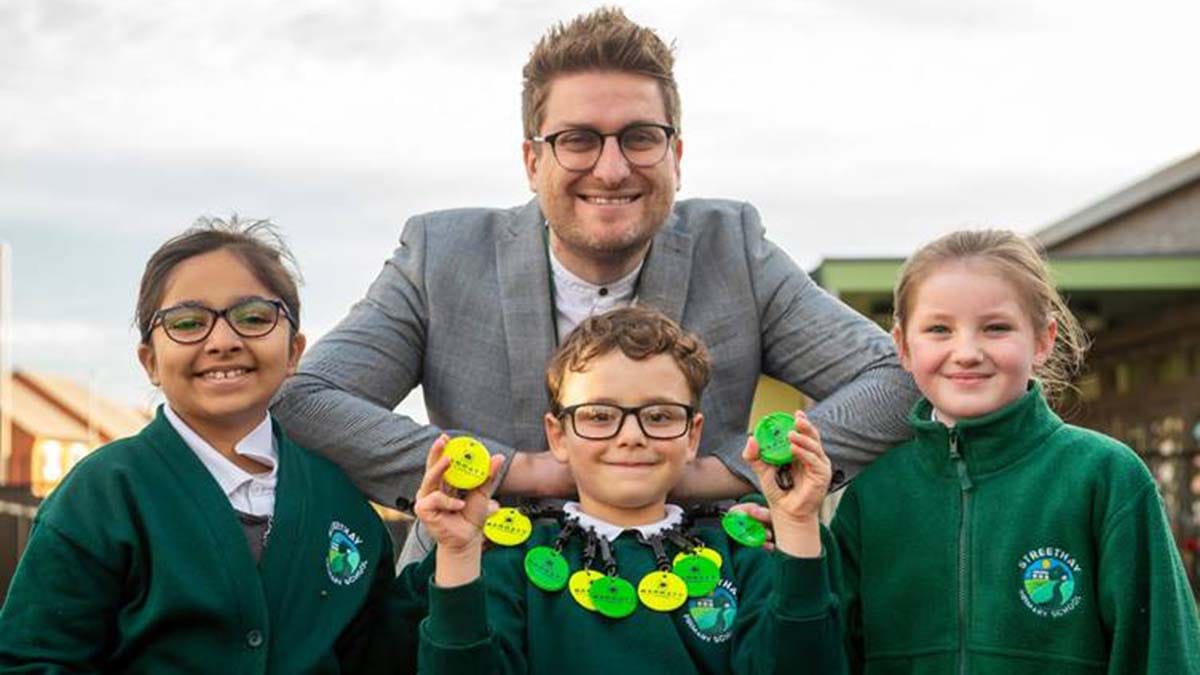 Headteacher Stuart Taylor with pupils and the new reflective bag tags