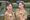 Women in wartime military costume blowing kisses to the camera