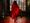 A man in red lighting walking in a gothic setting