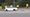 Vehicles driving past protesters outside The Friary School