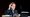 Woman sat at a desk holding a telephone