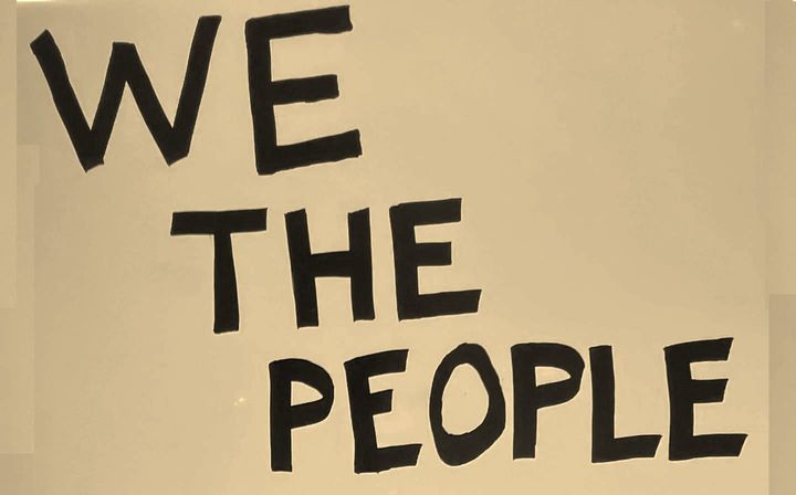 hand lettered "We The People" sign