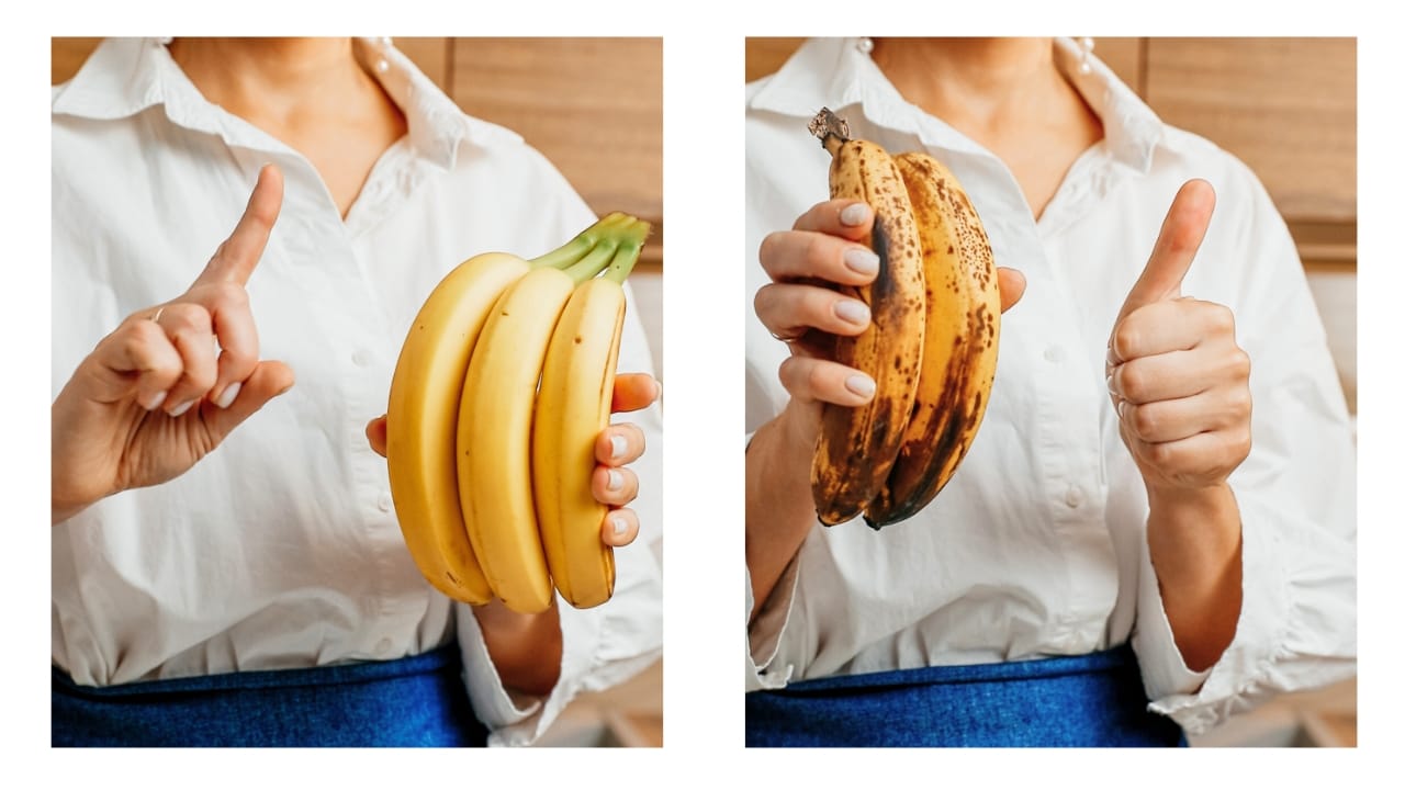 A home cook holding ripe and unripe bananas in order to make banana bread.
