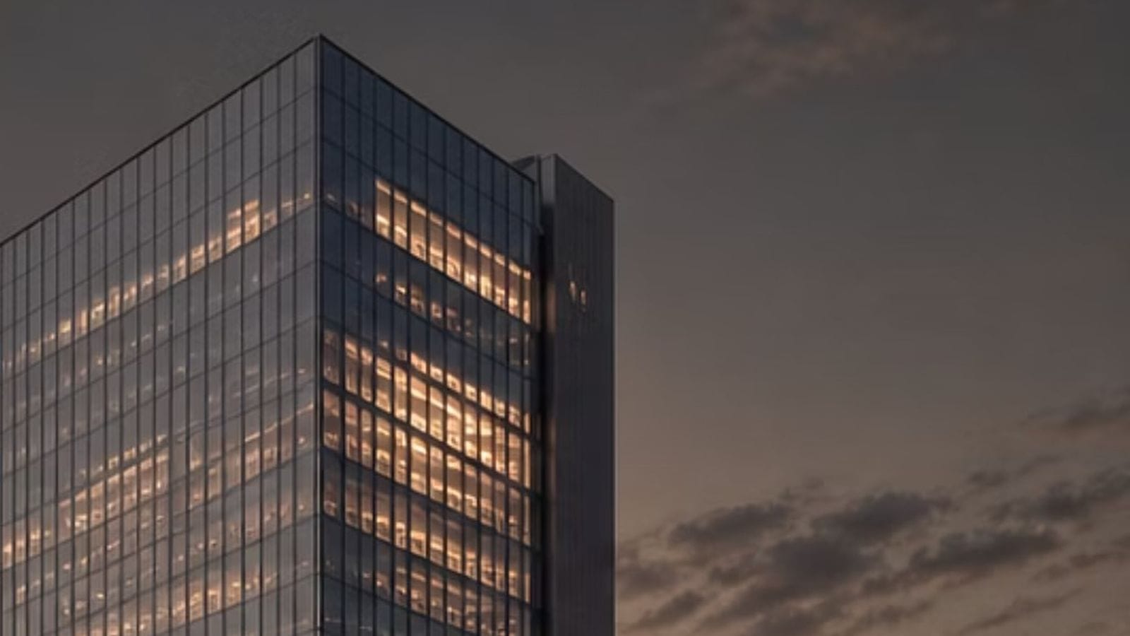 Glass office tower lit from within at dusk