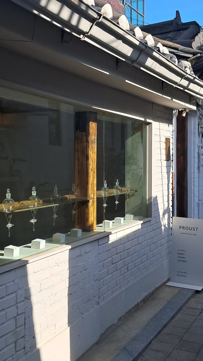 White hanok exterior of PROUST with perfume vessels in the window, Hyehwa, Seoul