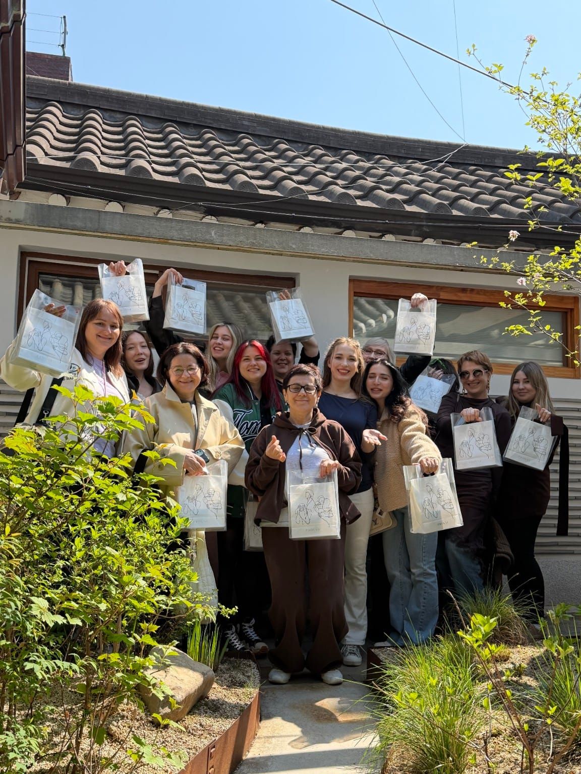 Workshop guests holding PROUST perfume bags in the hanok garden