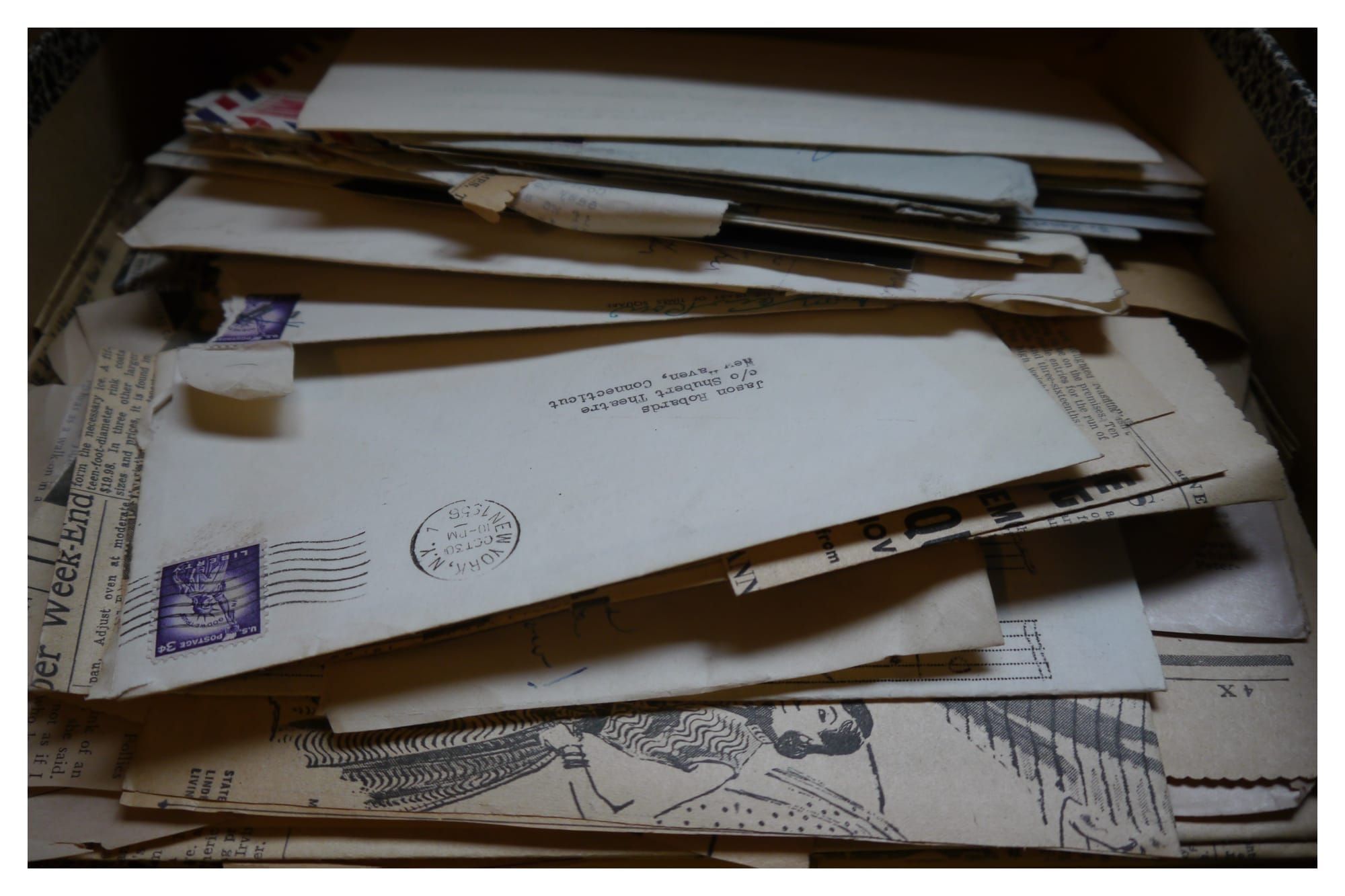 A photograph of a pile of letters and newspaper clippings, with one on top addressed to Jason Robards.