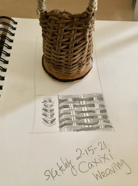 A caxixi sits upright on a white sketch pad page beneath which there is a sketch of its woven texture made by Liza Bernstein with the words "sketching caxixi weaving  2-15-21"