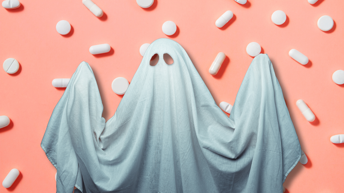 Illustration of a ghost draped in a white sheet with two holes cut out for the eyes against the backdrop of pills