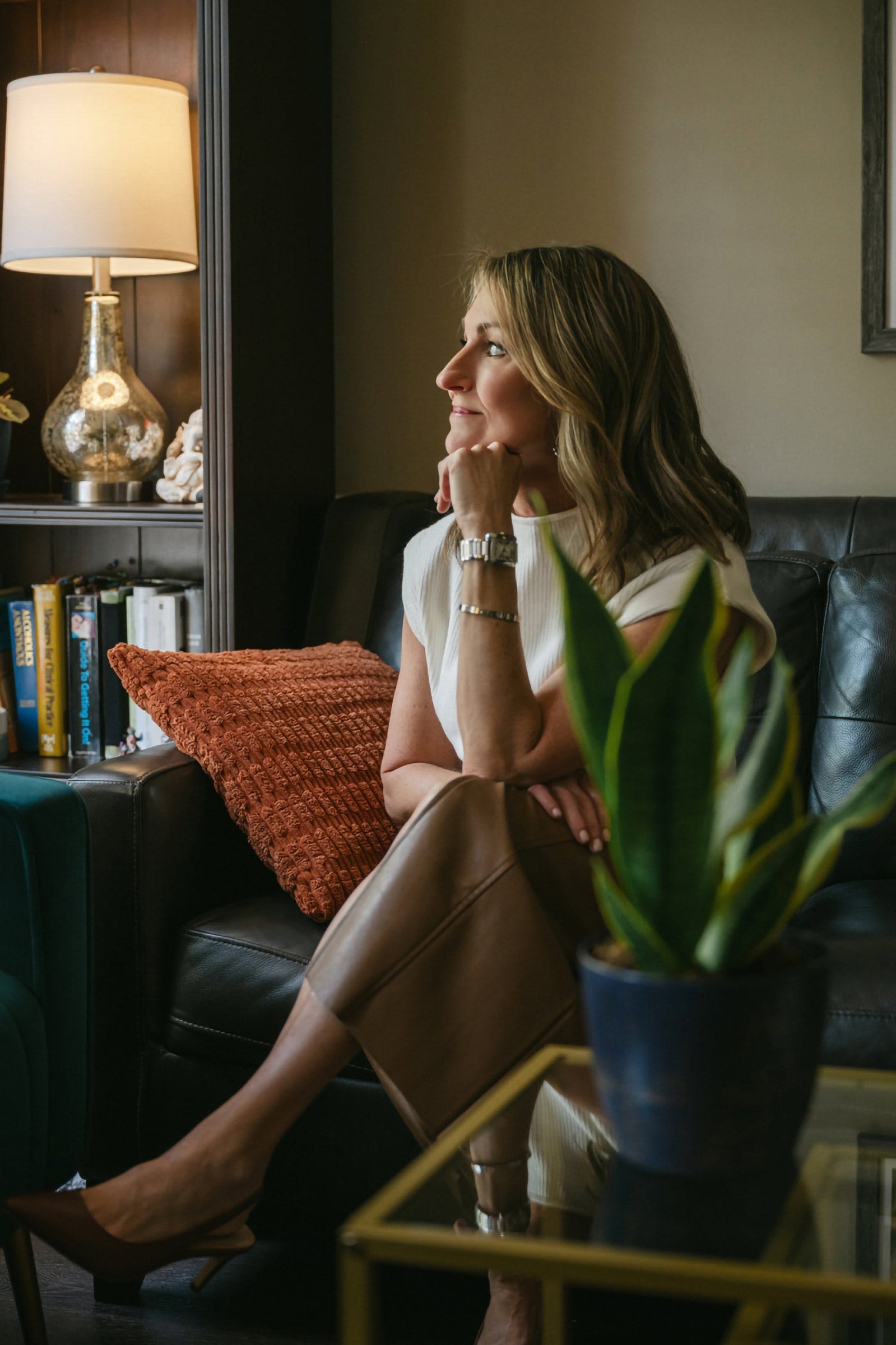 Woman gazing out of frame in a moody, lamp-lit study