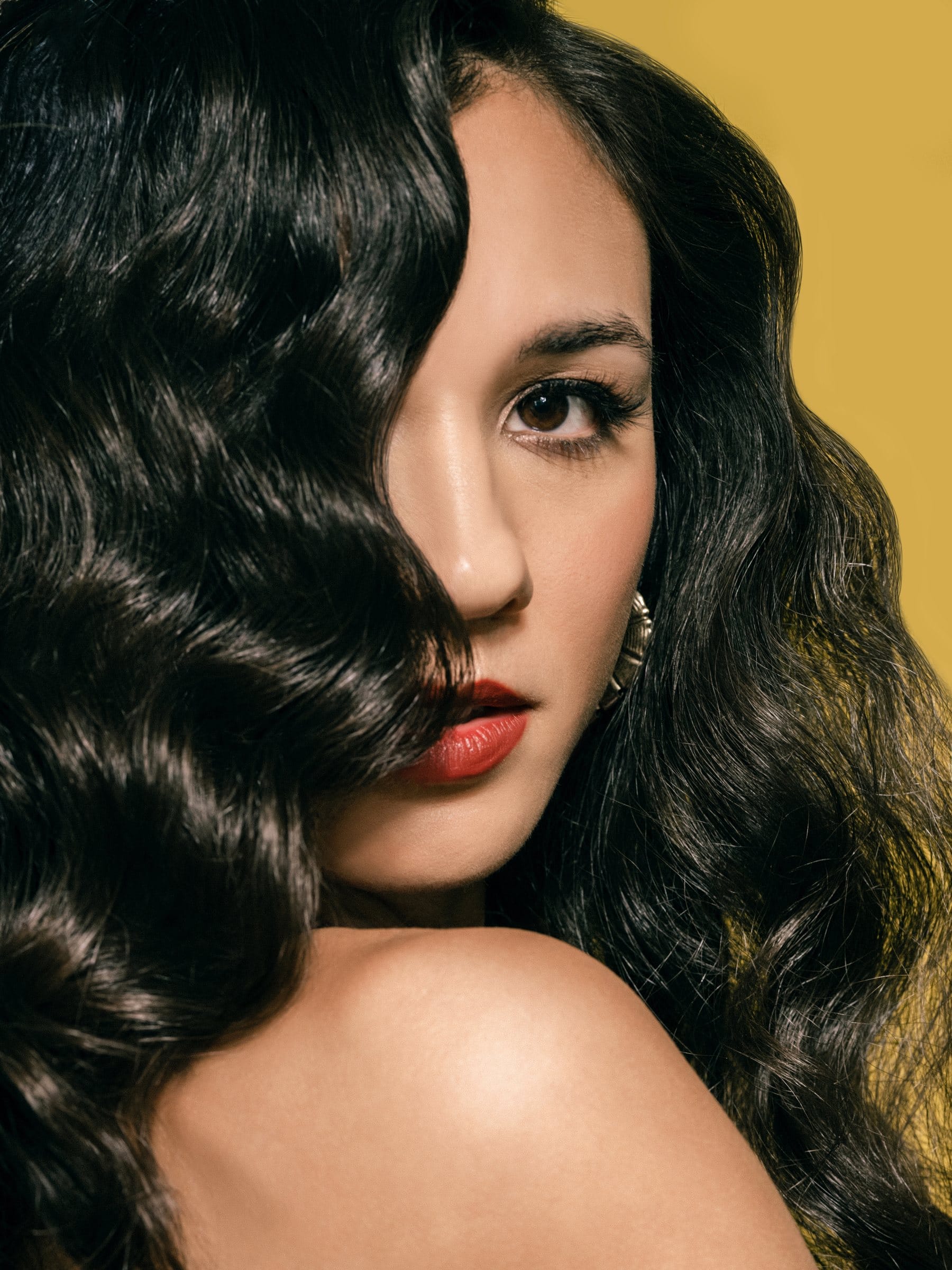 Old Hollywood portrait with glossy waves against mustard