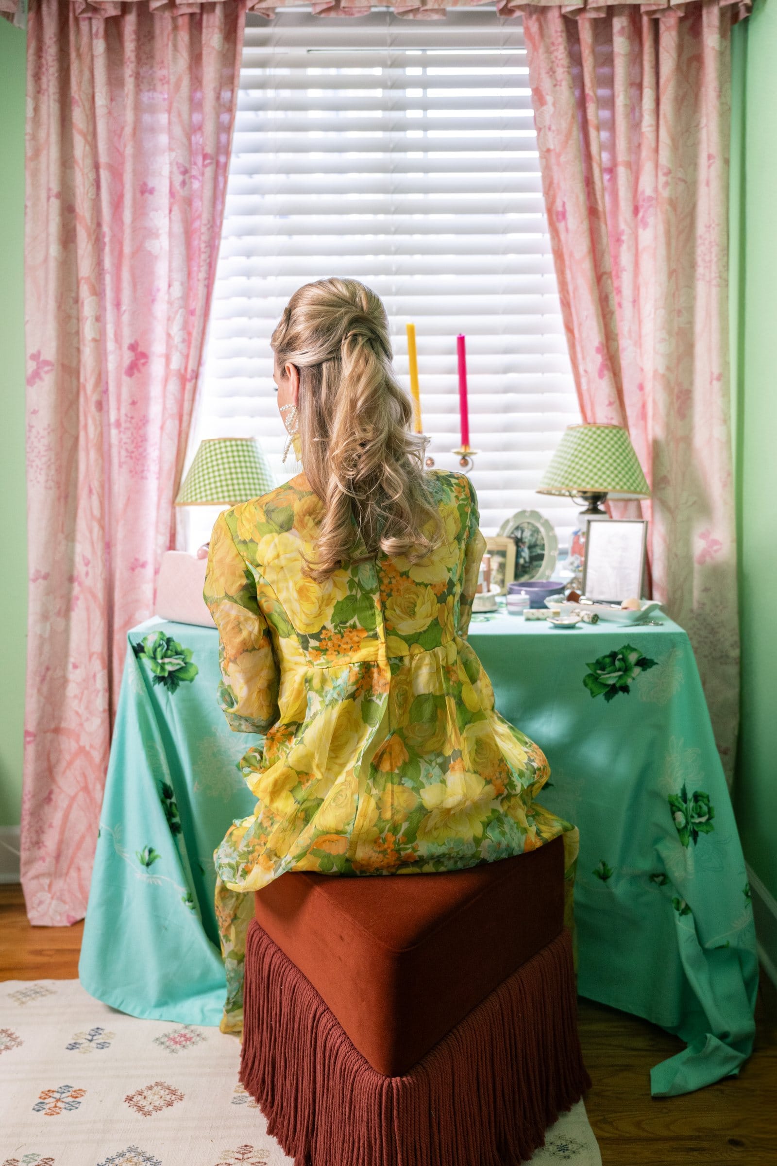 Woman in a yellow floral jacket at a retro vanity table