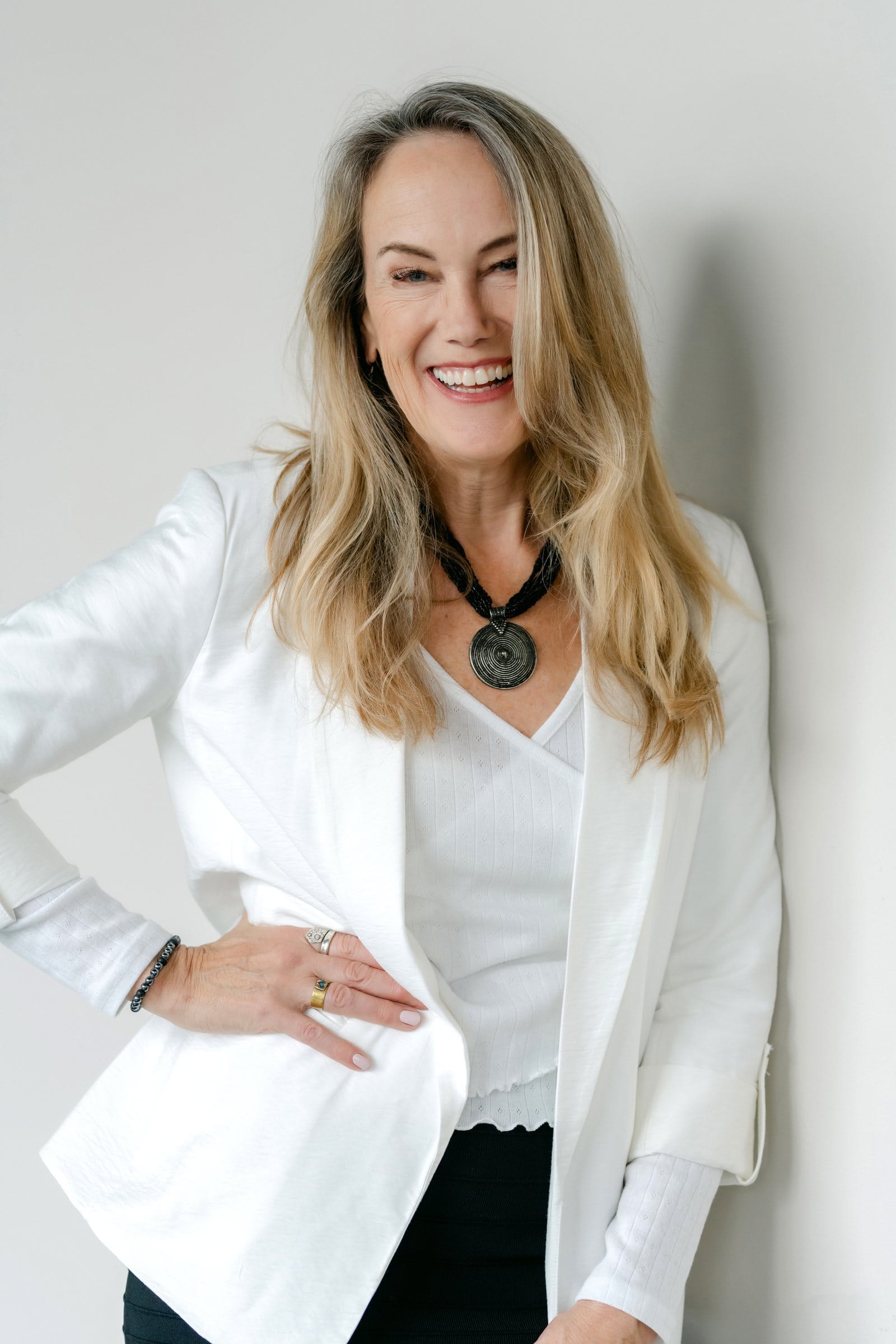 Confident woman in a white blazer with her hand on her hip