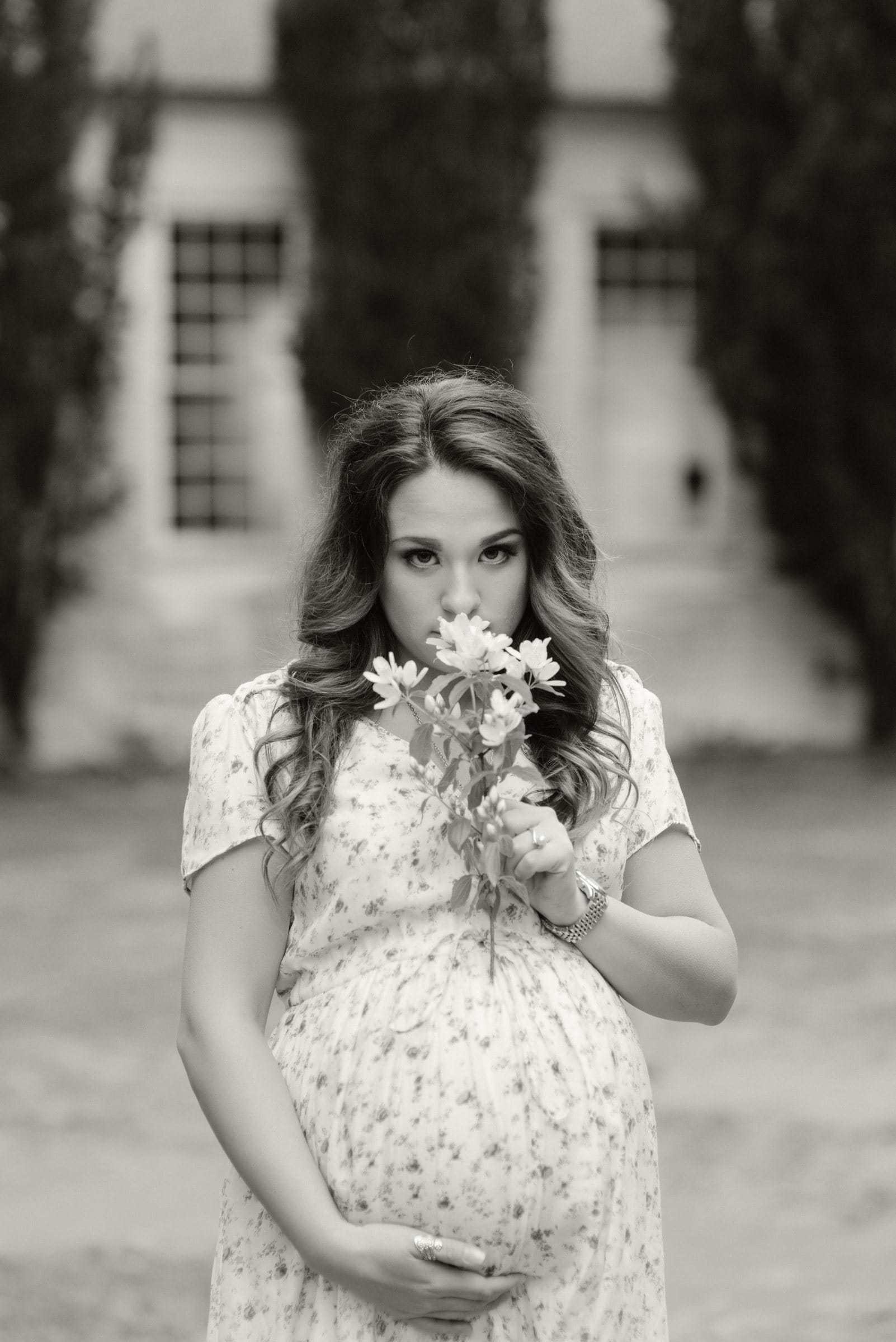 Black and white maternity portrait holding a bouquet