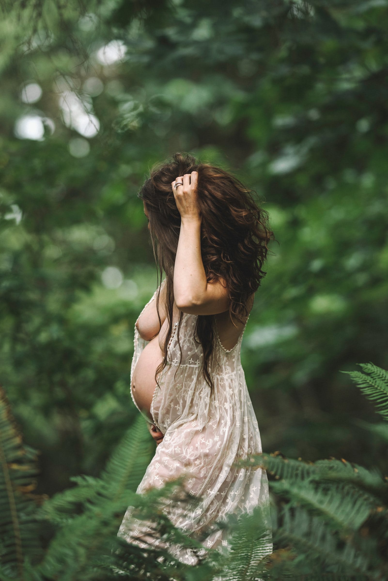 Expectant mother in a lace slip among forest ferns