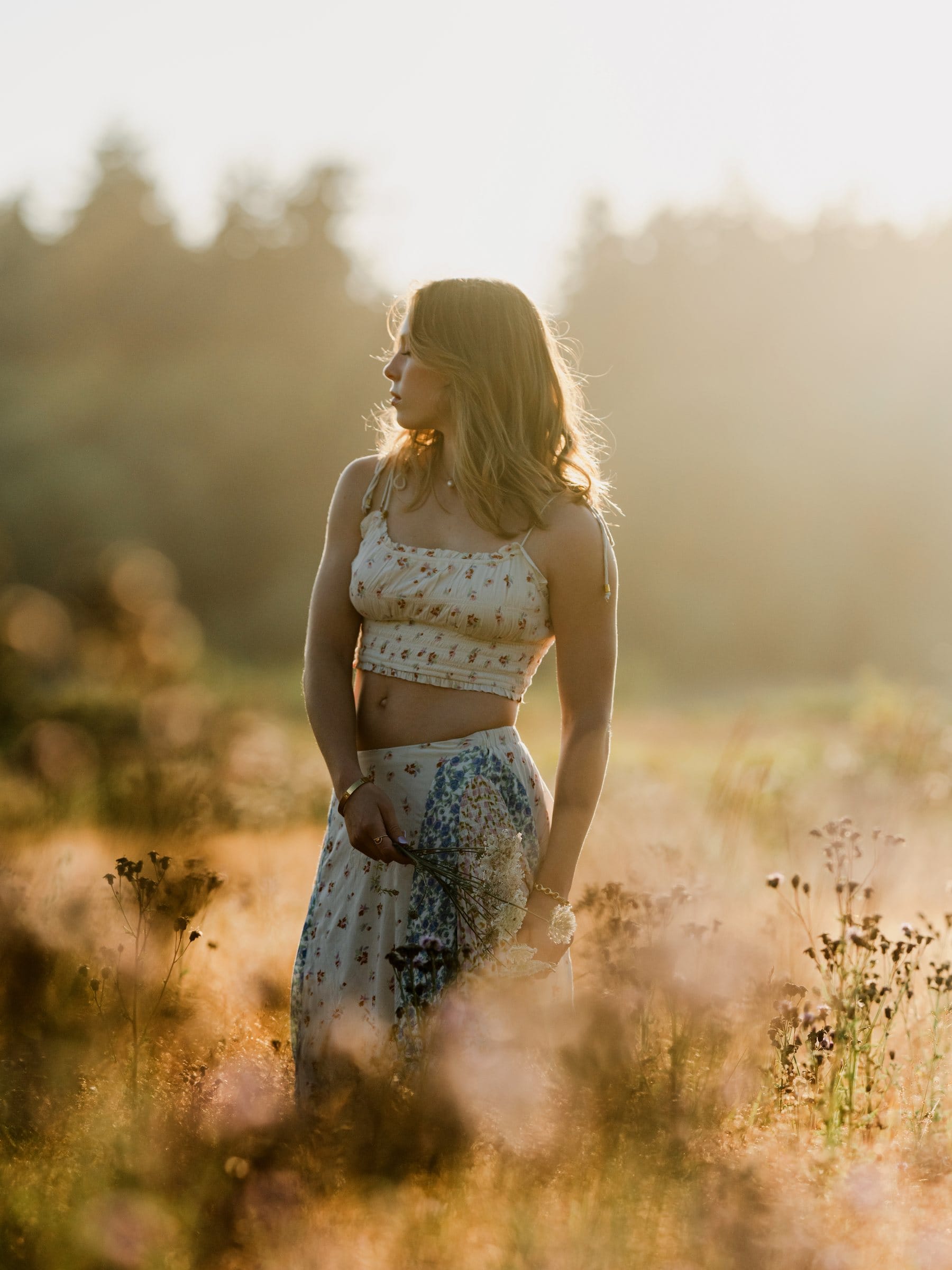 Young woman in a golden meadow at sunset
