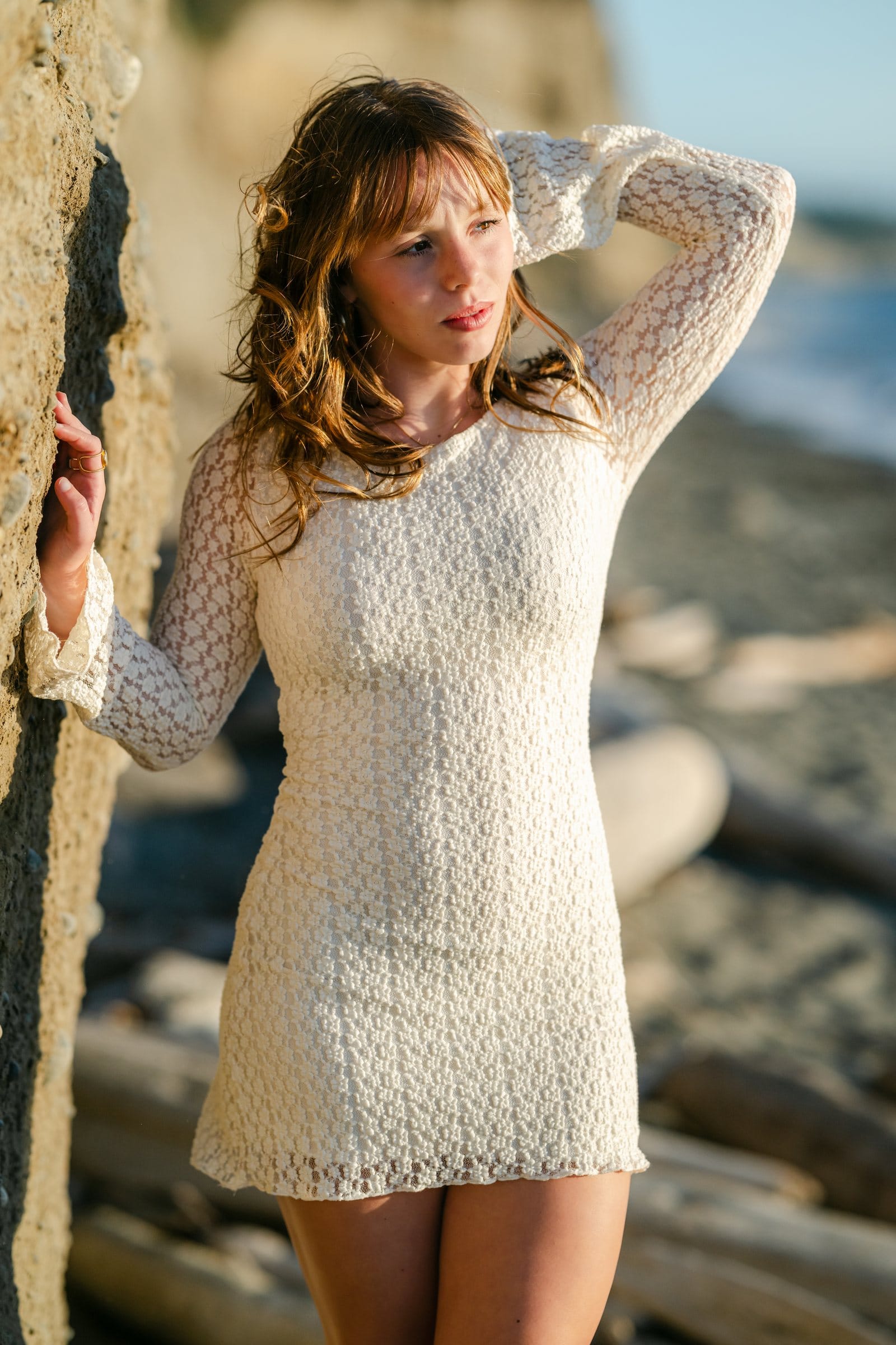 Young woman in a lace dress by a seaside cliff