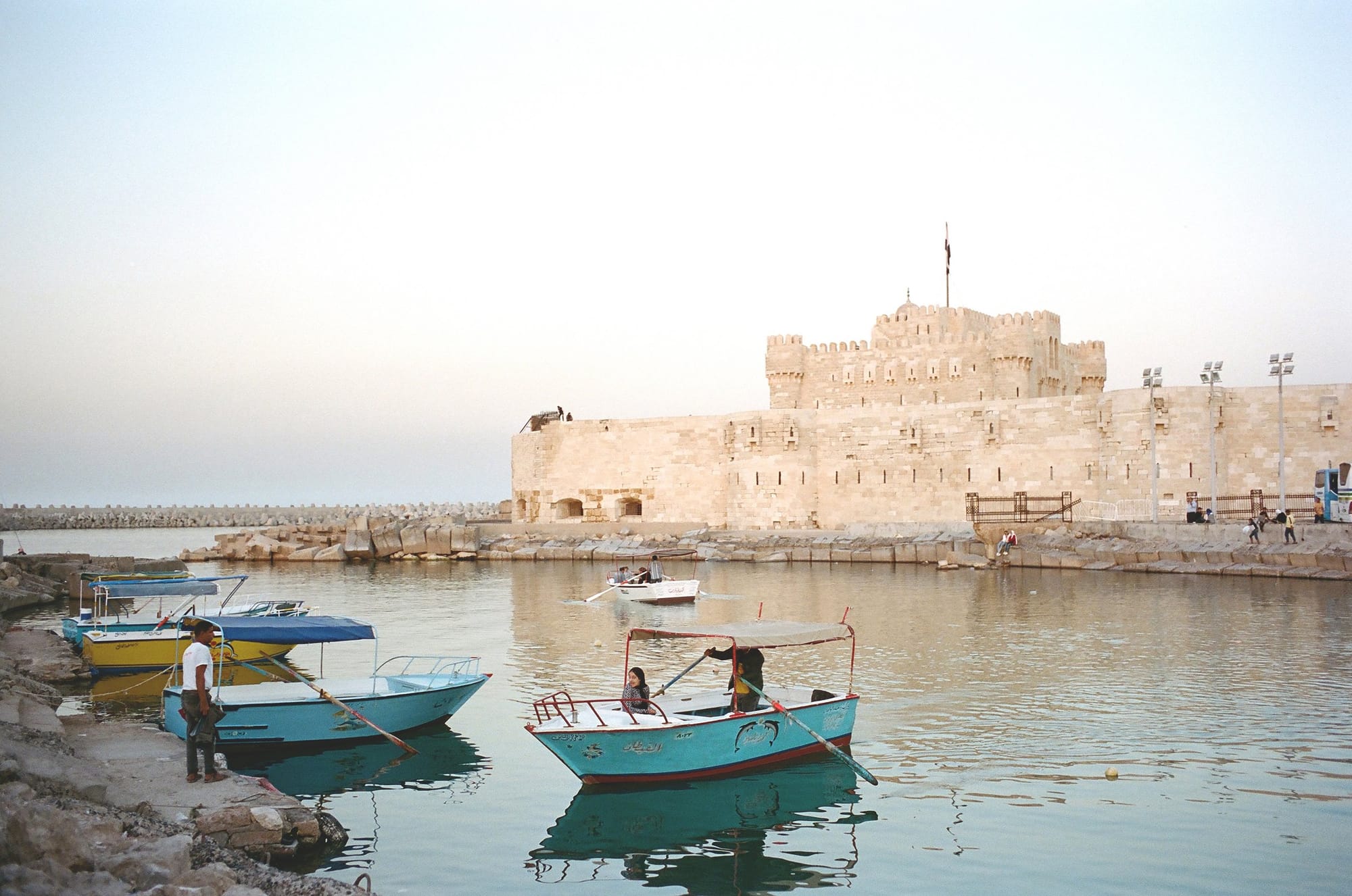 Fishing boats in front of a seaside fortress
