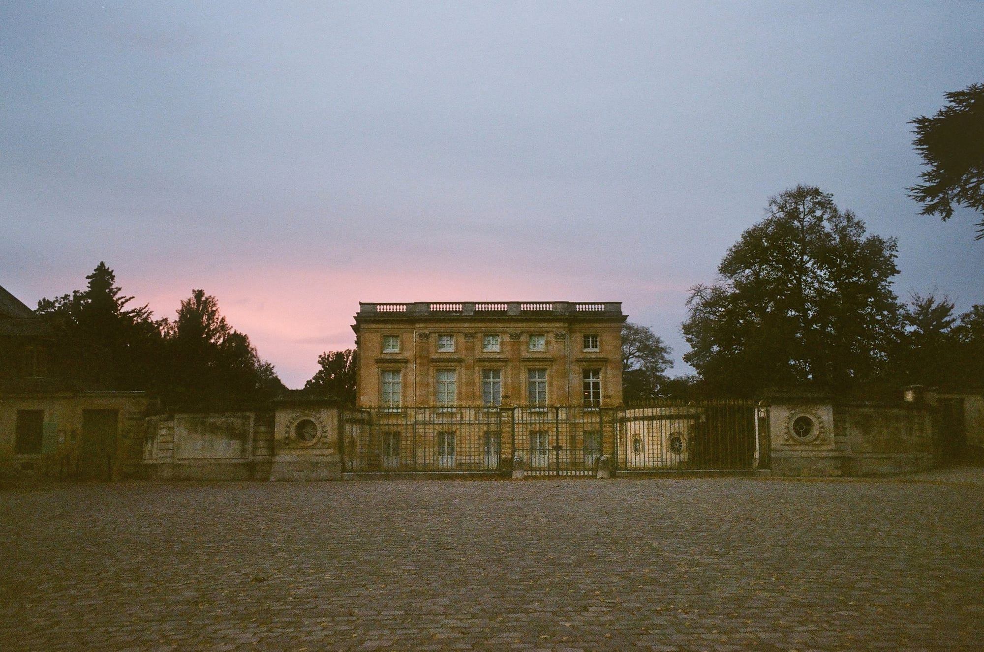 French palace at dusk under a pink sky