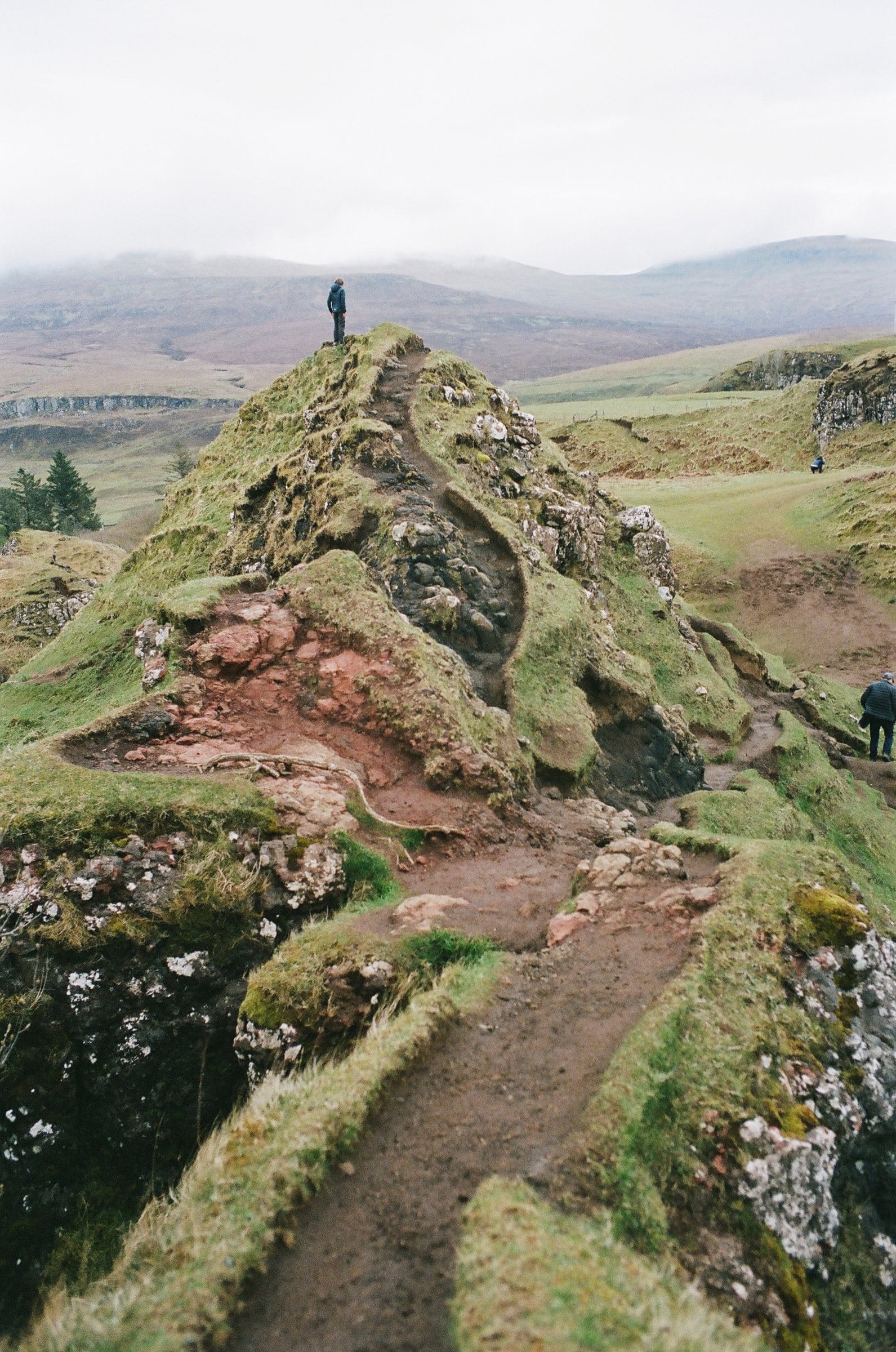 Hiker on a green ridge in the Scottish highlands