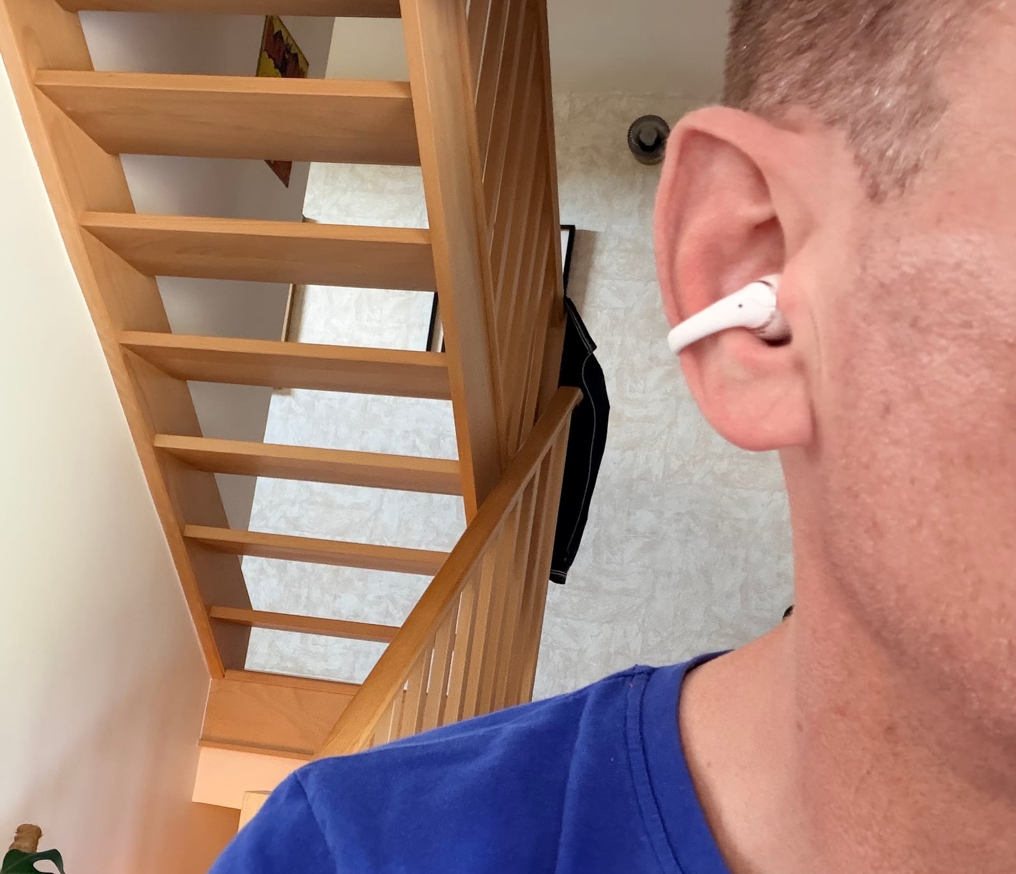 Shokz OpenDots 2 en pearl white clipsé sur l'oreille, vue de profil montrant le maintien du clip et la compacité de l'écouteur