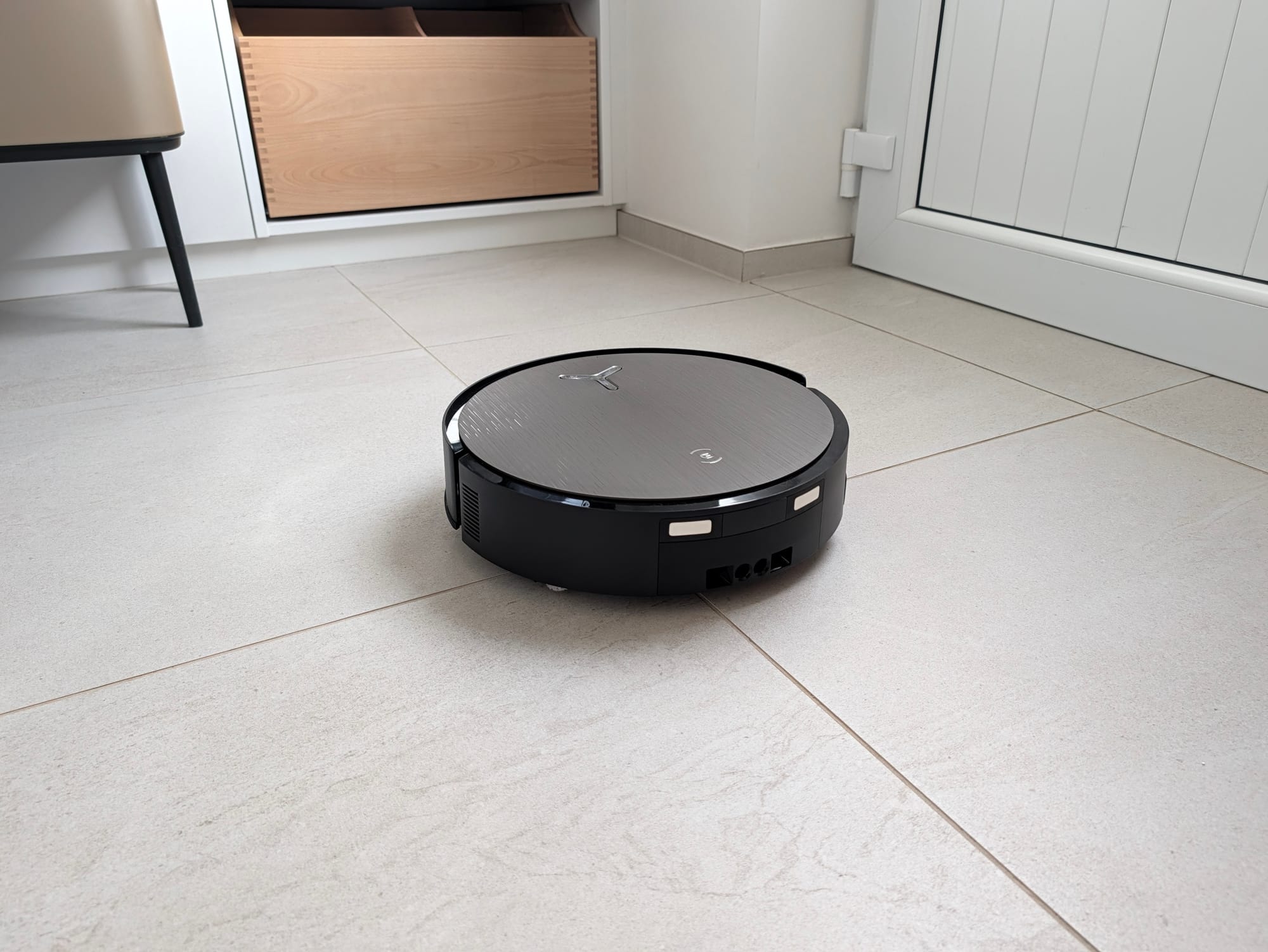 DEEBOT X12S OmniCyclone en déplacement sur un sol carrelé clair, meuble en bois clair