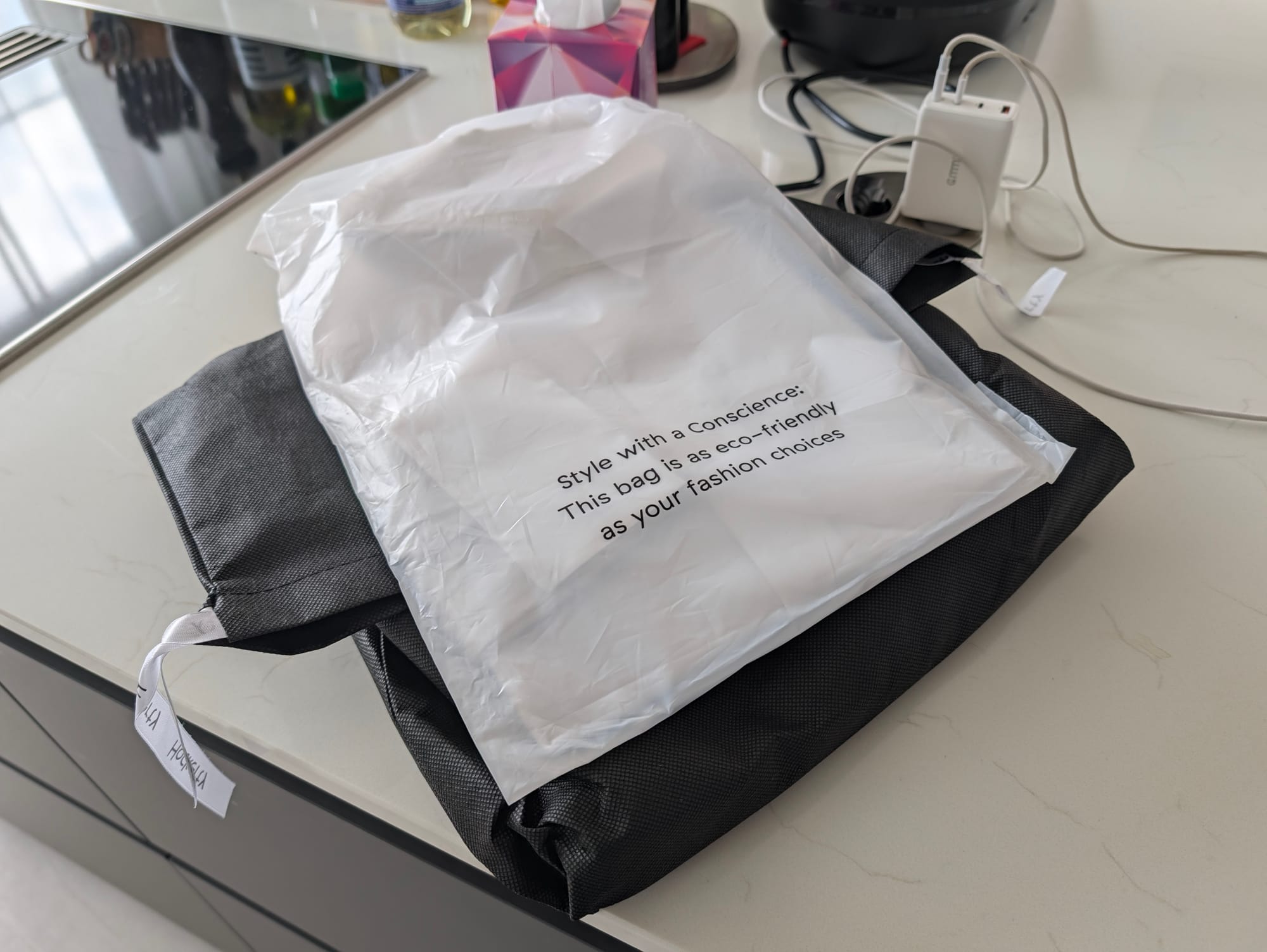 Colis Hockerty emballé dans un sac écologique avec l'inscription Style with a Conscience sur un plan de travail