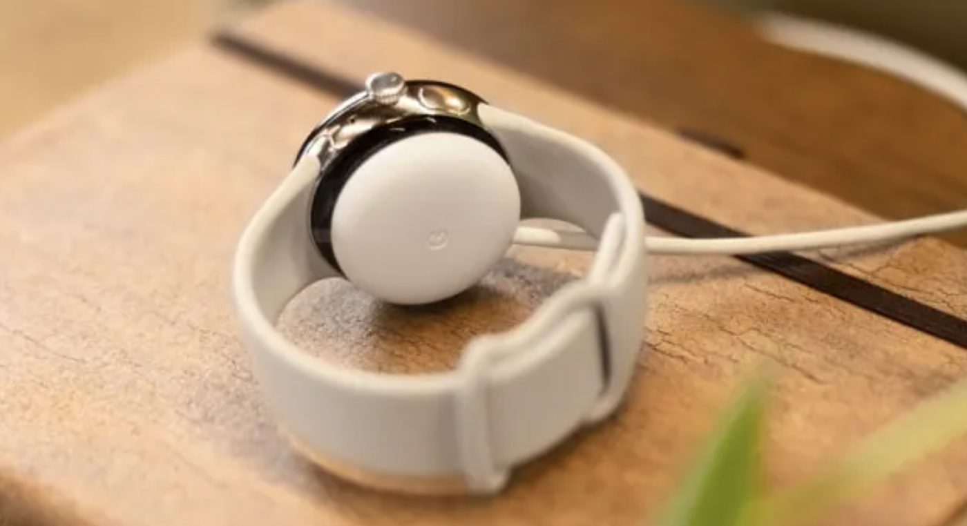 Pixel Watch 5 posée sur son chargeur propriétaire à induction, câble USB-C relié au socle
